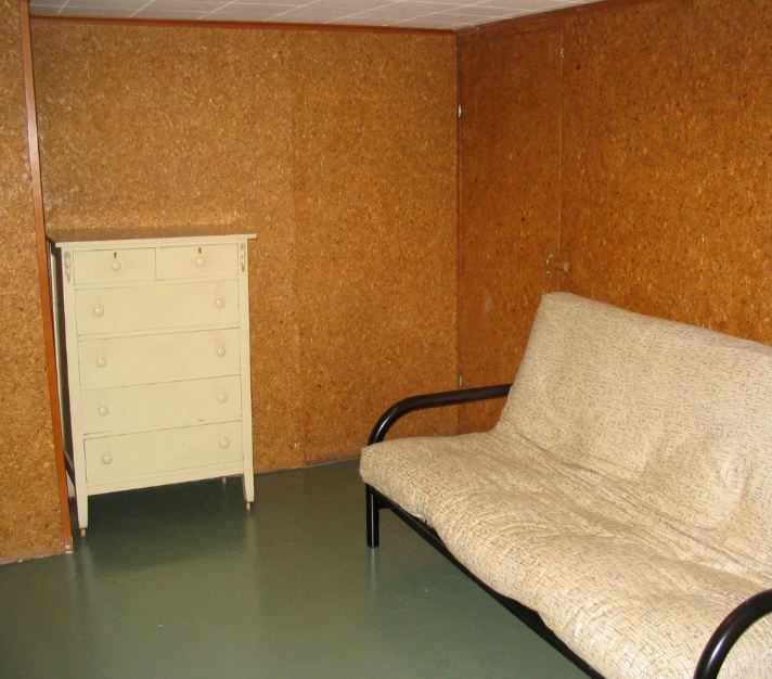 A bedroom with a bed and desk in a room