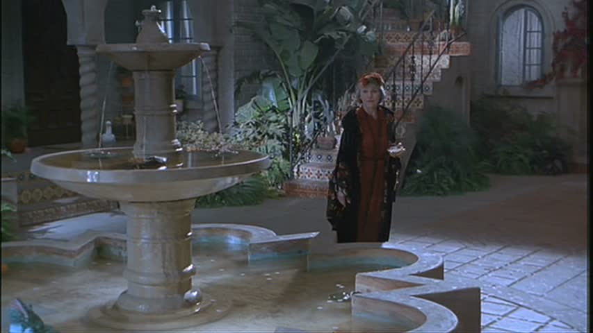 a woman standing beside the fountain at night