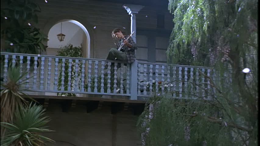 A person sitting on the railing on the upper level above the courtyard