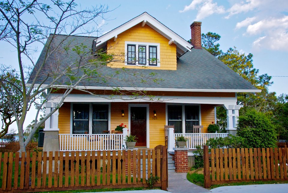 Sears Kit home called Vallonia today with yellow siding and picket fence