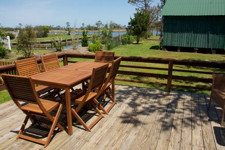 outdoor table and chairs overlooking the yard and water from back of house