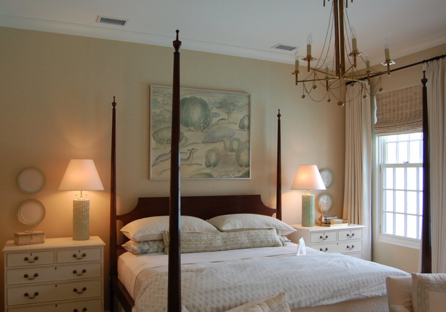 A bedroom with a four poster bed and chandelier