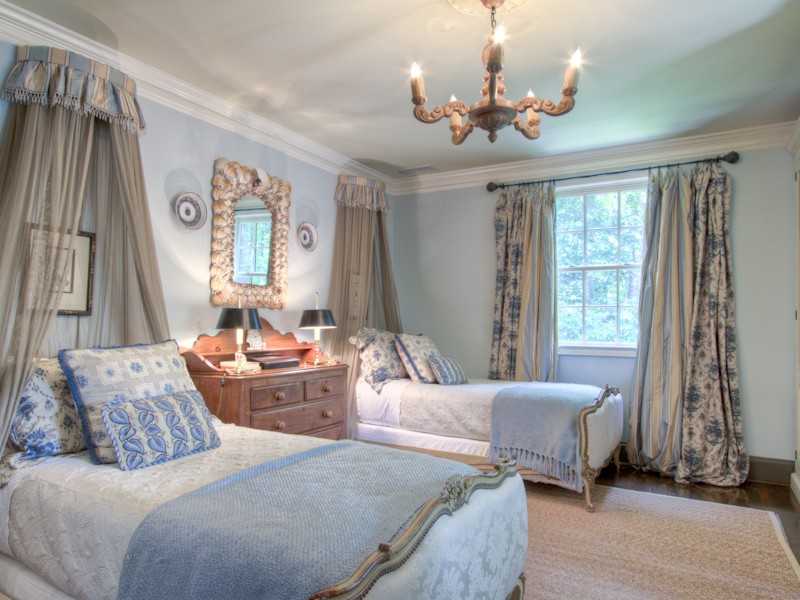 A bedroom with two twin beds and chandelier