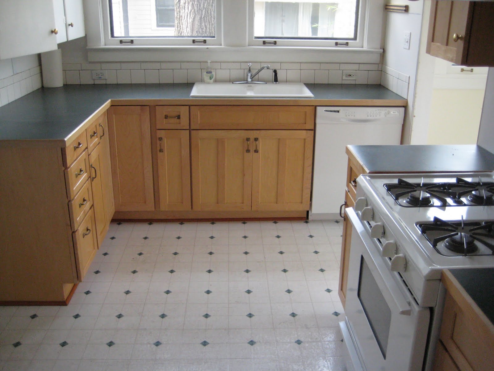 A kitchen with wooden cabinets and a window