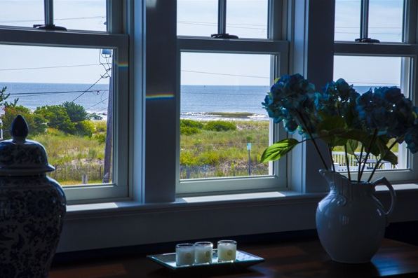 A vase of flowers sits in front of a window