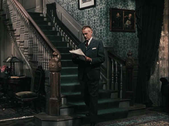 Clifton Webb standing at base of staircase in Cheaper by the Dozen movie