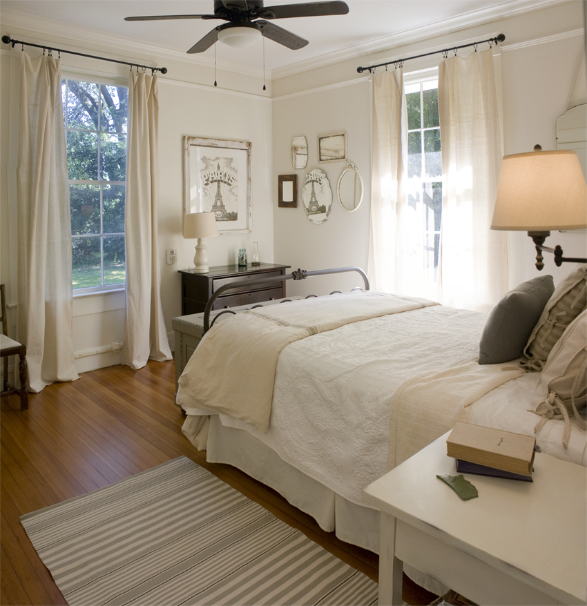 A bedroom with a bed and desk in a room