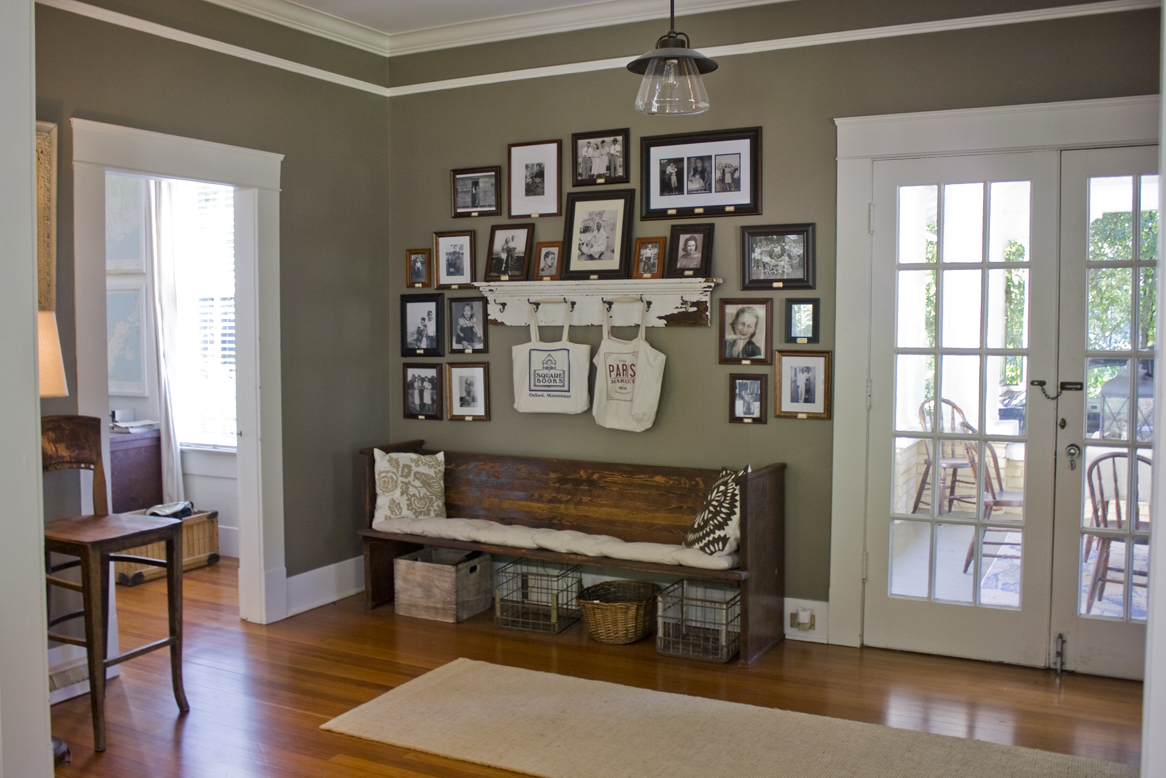 entry hall with framed photos and church pew