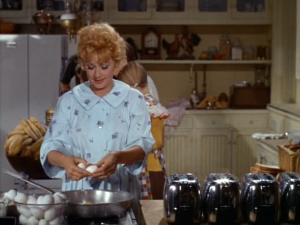 Lucille Ball preparing breakfast in kitchen