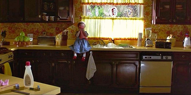 little girl sitting on counter next to sink