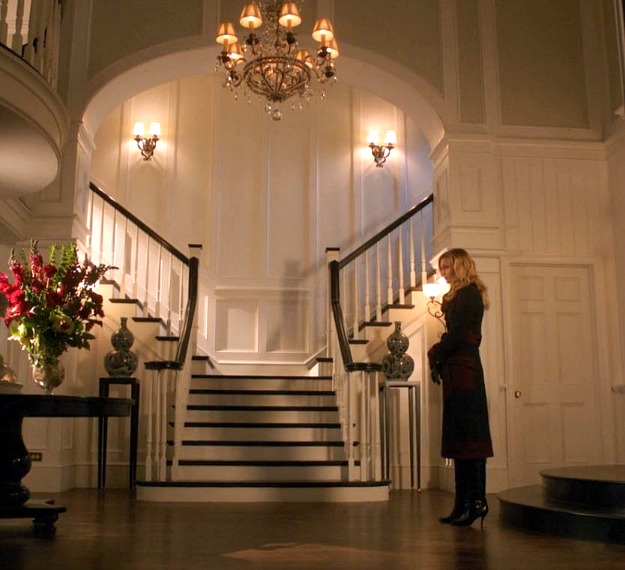 Emily Thorne standing in front of double staircase in Grayson Manor