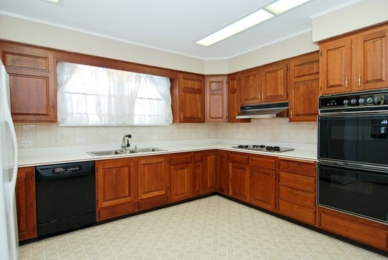 A large kitchen with stainless steel appliances and wooden cabinets