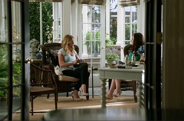 Emily and Victoria sitting in wicker chairs in the conservatory