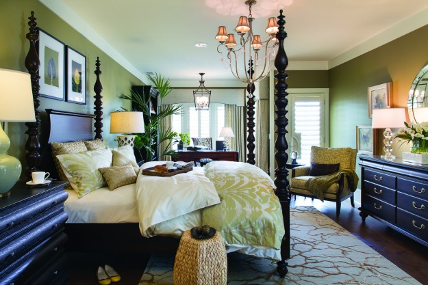 A bedroom with four poster bed and green walls