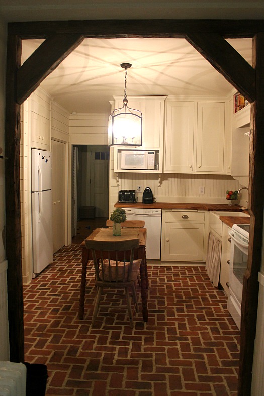 A kitchen with a red brick floor