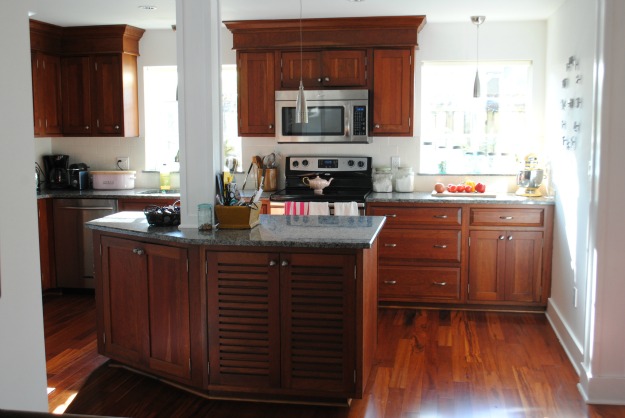 A kitchen with wooden cabinets and a wood floor