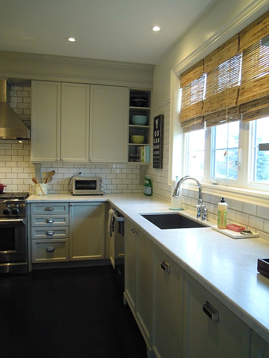 A kitchen with a stove a sink and a window