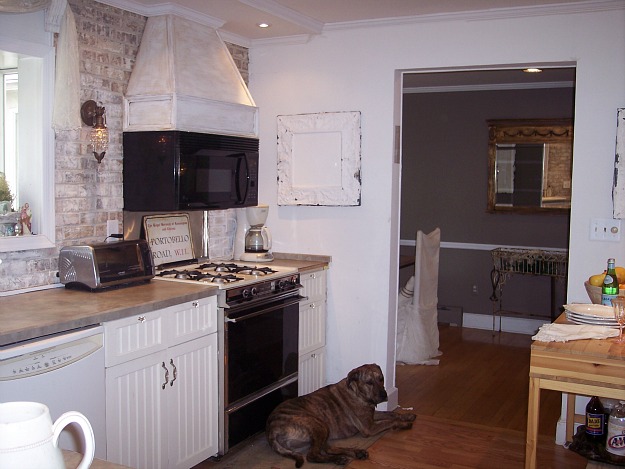 A kitchen with vent hood over microwave