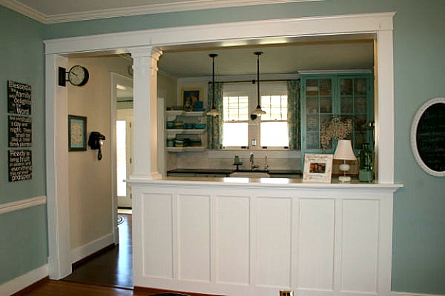 A kitchen with a large pass through to dining room