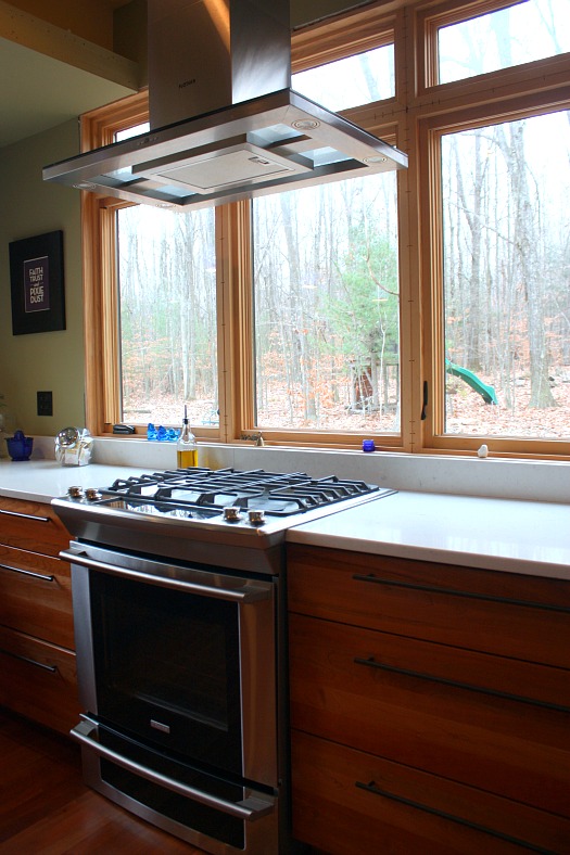 A kitchen with a stove top oven sitting next to a window