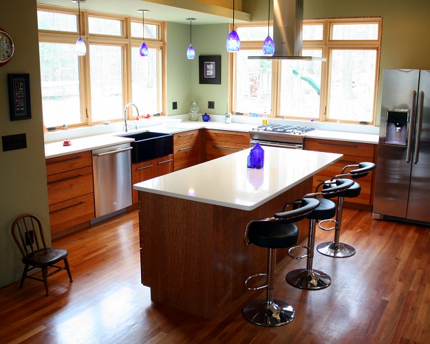 A kitchen with an island in the middle of a hard wood floor