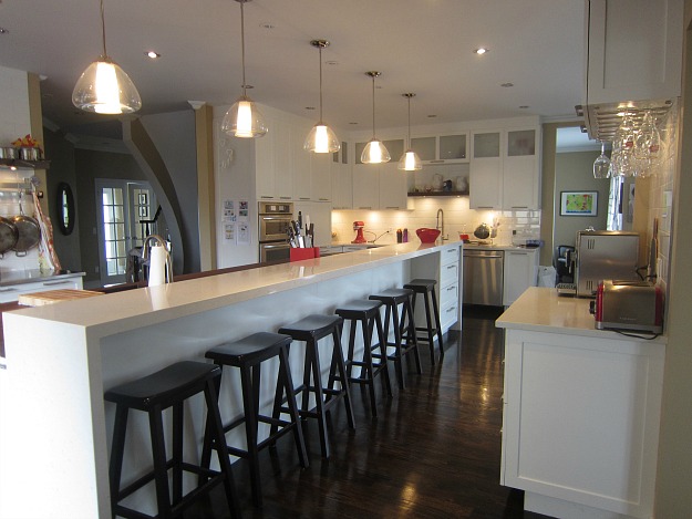 A kitchen with an extra long island and barstools