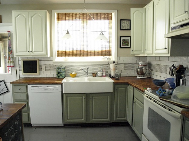 A kitchen with a stove a sink and a microwave