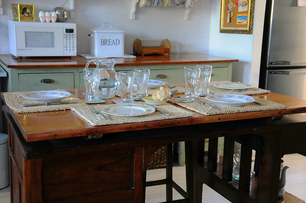 kitchen table set with glasses and plates