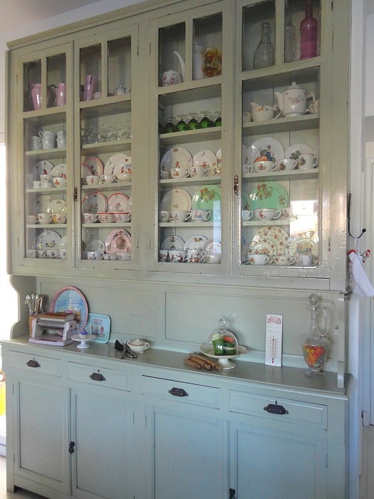 closeup of china cabinet with plates and teacups inside