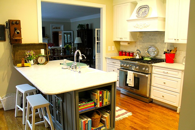 A kitchen with large vent hood over stainless range