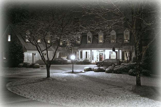 A view of a house at night with lights on