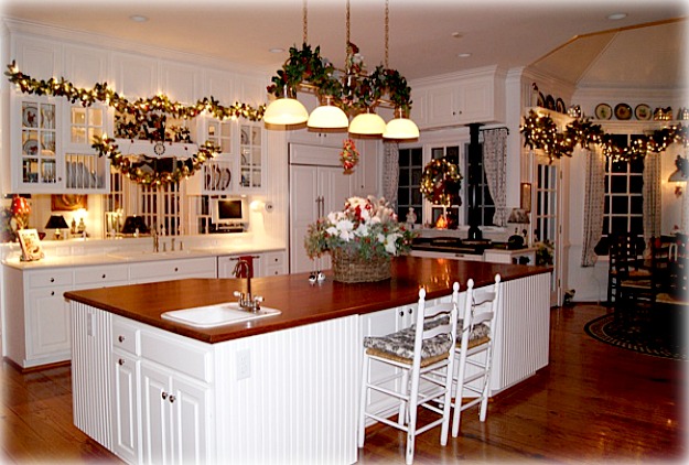 A kitchen with large white island decorated for Christmas