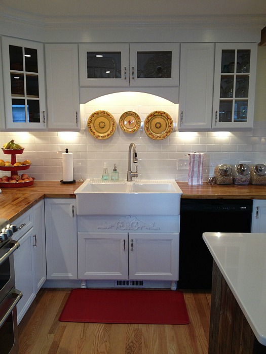 closeup of farm sink with decorative plates hung over it