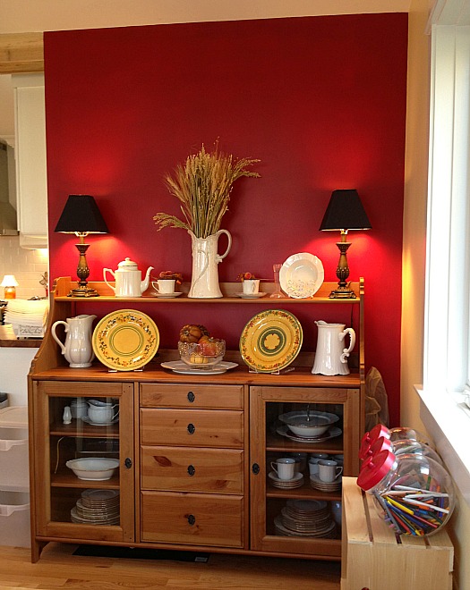 buffet set against red wall in dining area