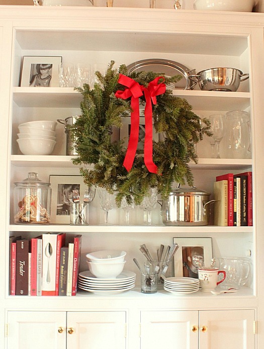 wreath with red ribbon hanging from shelves