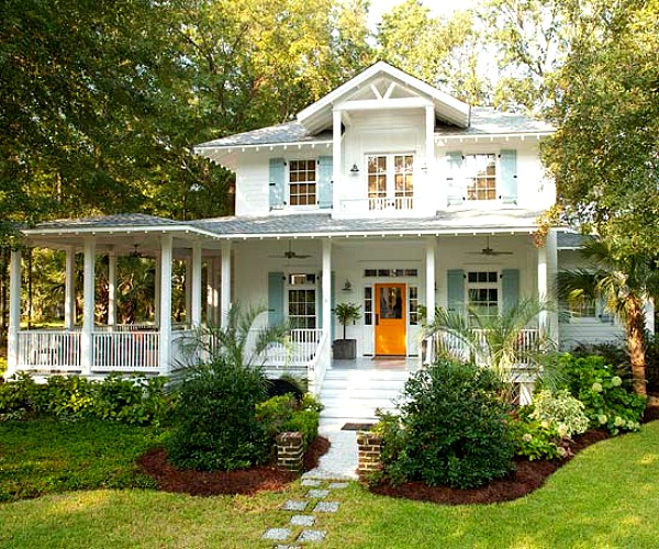 front exterior of coastal cottage that has orange door and pale blue shutters