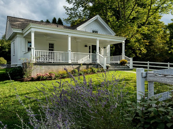 A garden in front of a small house with big front porch