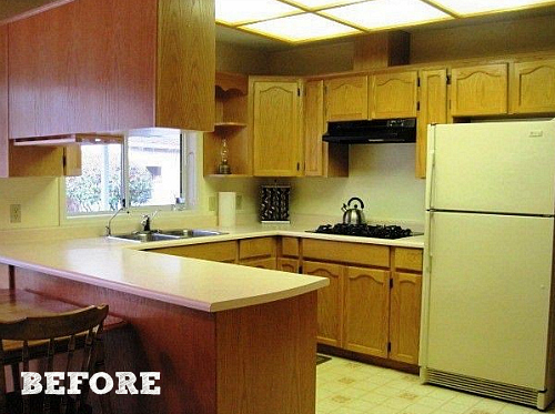 A kitchen with a stove and a refrigerator before remodel