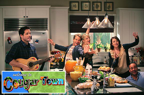 cast of Cougar Town TV show in Jules\'s kitchen with logo inset