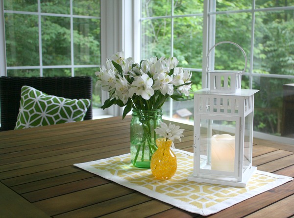 A vase of flowers on a table next to a window