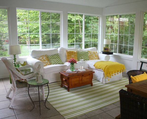 large sunroom with Ektorp sofa from IKEA and green and white stripe rug