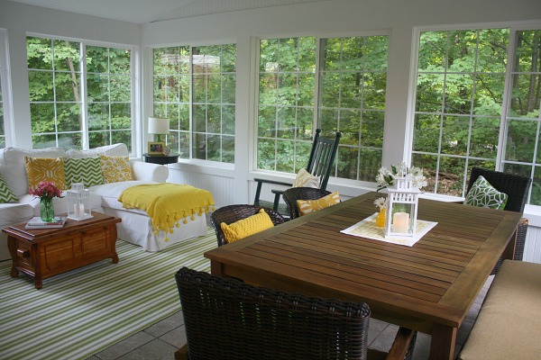 A sunroom filled with furniture and large windows