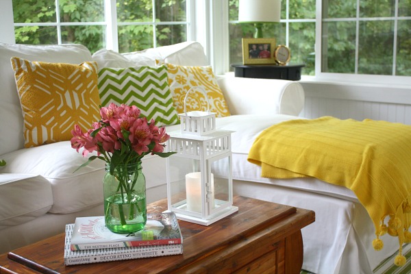 closeup of green Ball jar with flowers on cedar chest in sunroom