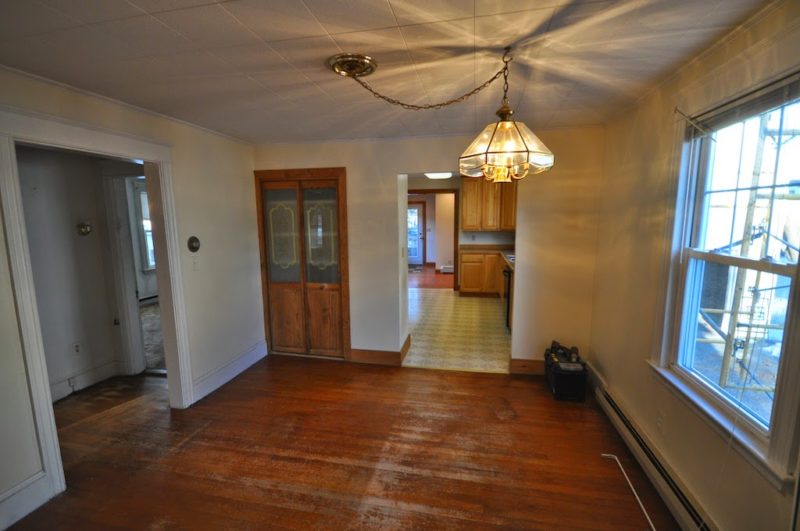 A view of a living room with a wood floor before remodel