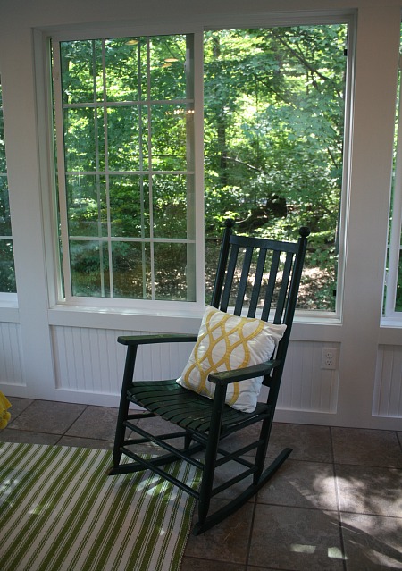 green rocking chair in the sunroom