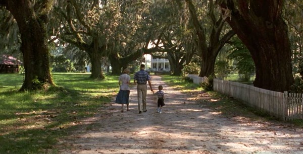 Jenny, Forrest and their son walk down the lane to the house