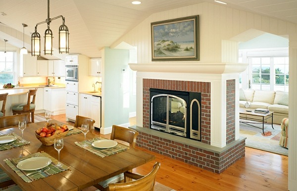 dining table next to red brick fireplace in beach house