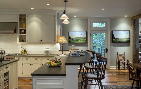 A kitchen with two tier island and bar stools