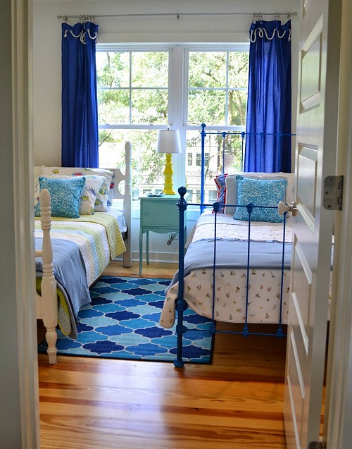 kid\'s bedroom with two twin beds and blue curtains