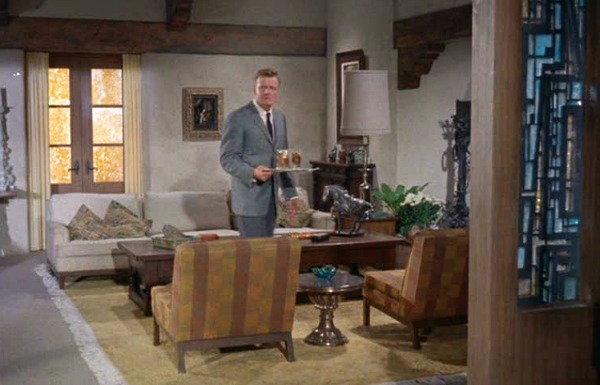 Brian Keith standing in living room